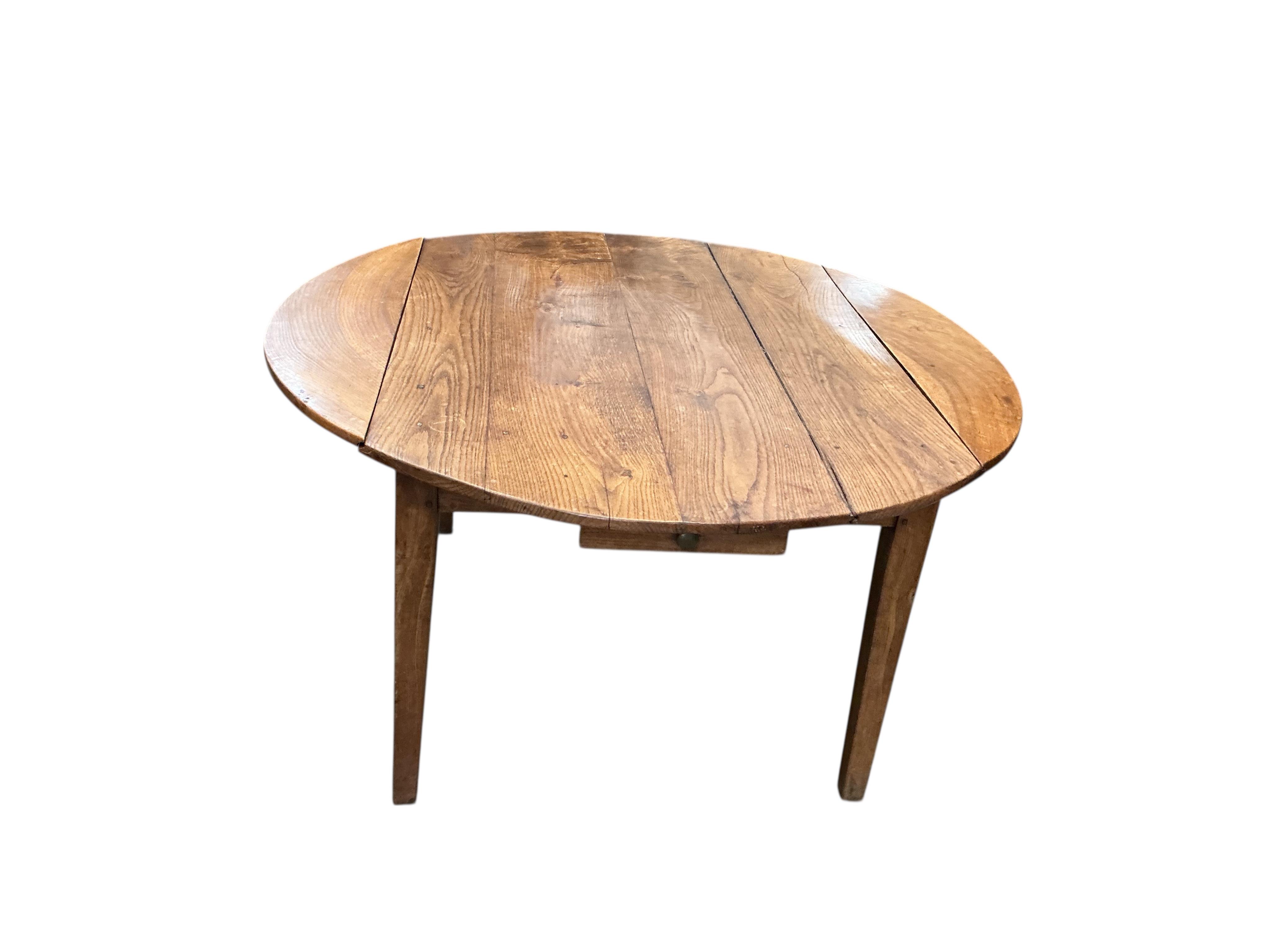 A 19th century French Provincial oak drop leaf dining table, diameter 138cm, extended, height 73cm